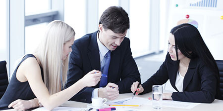 3 arbeitende Personen an einem Konferenztisch 3 arbeitende Personen an einem Konferenztisch