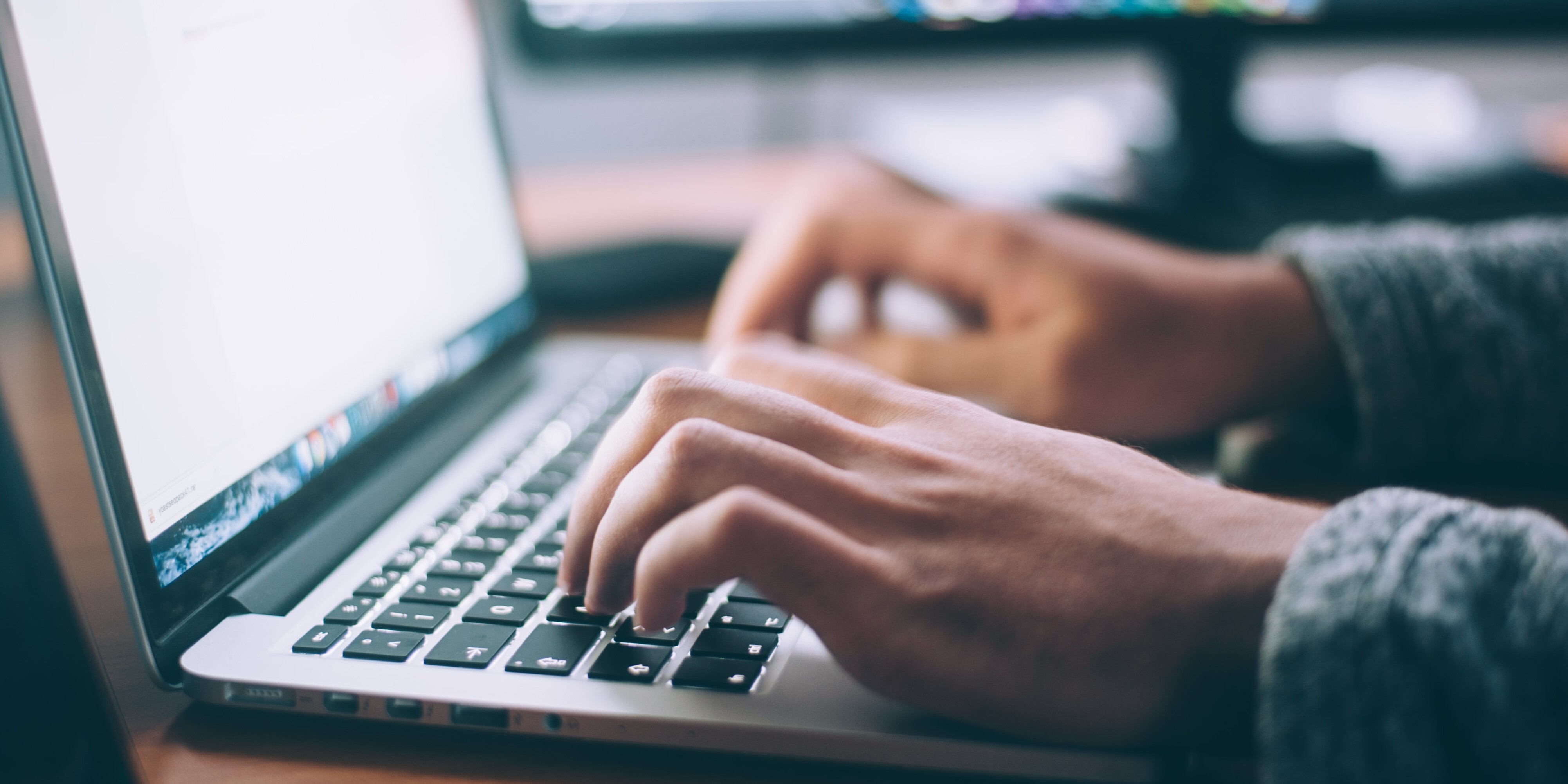 Mann tippt etwas auf Laptop Tastatur